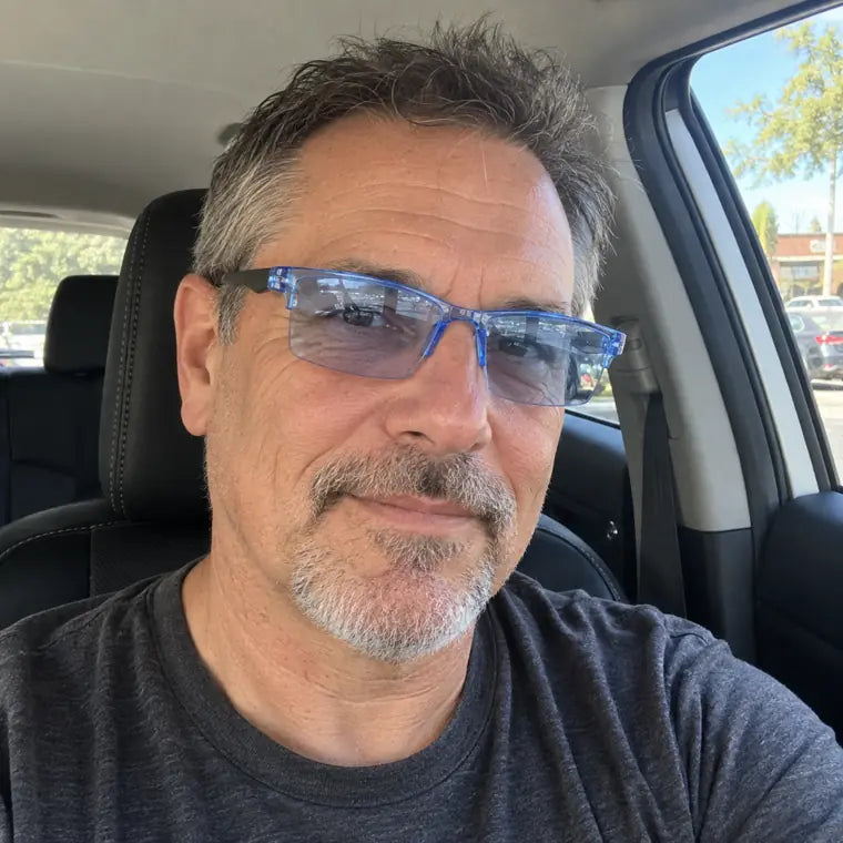 Customer wearing blue clear frame glasses while sitting in a car