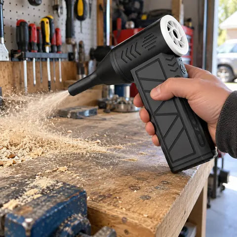 Air duster clearing sawdust from a workshop bench