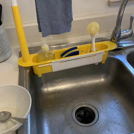 Yellow sink organizer set beside faucet with towel bar