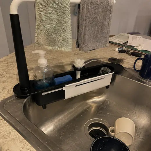 Black sink organizer with two towels hanging from the bar