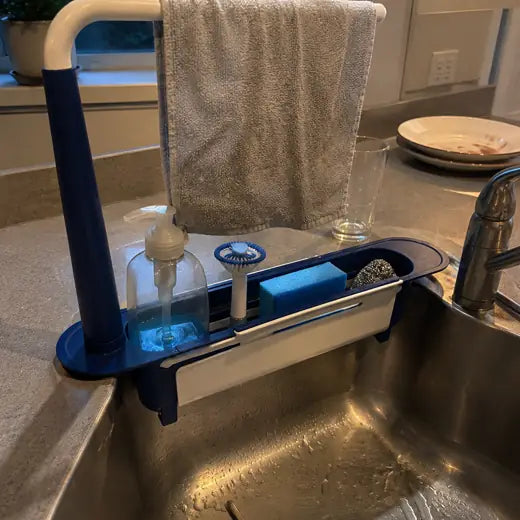 Blue sink rack with towel and sponge beside a kitchen sink