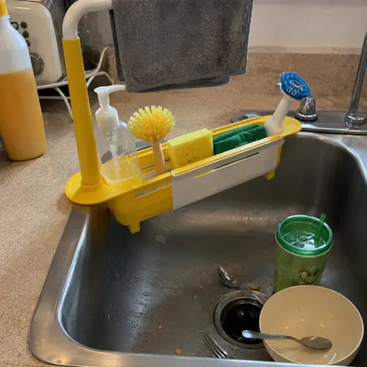 Yellow sink rack holding soap brush sponge and dish cloth