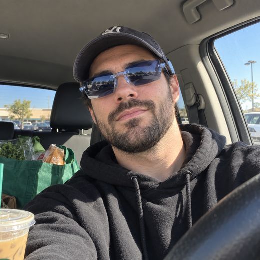 Man wearing blue tinted glasses inside parked car