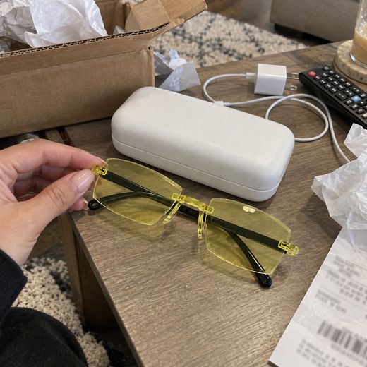 Yellow smart zoom glasses unboxed beside white glasses case