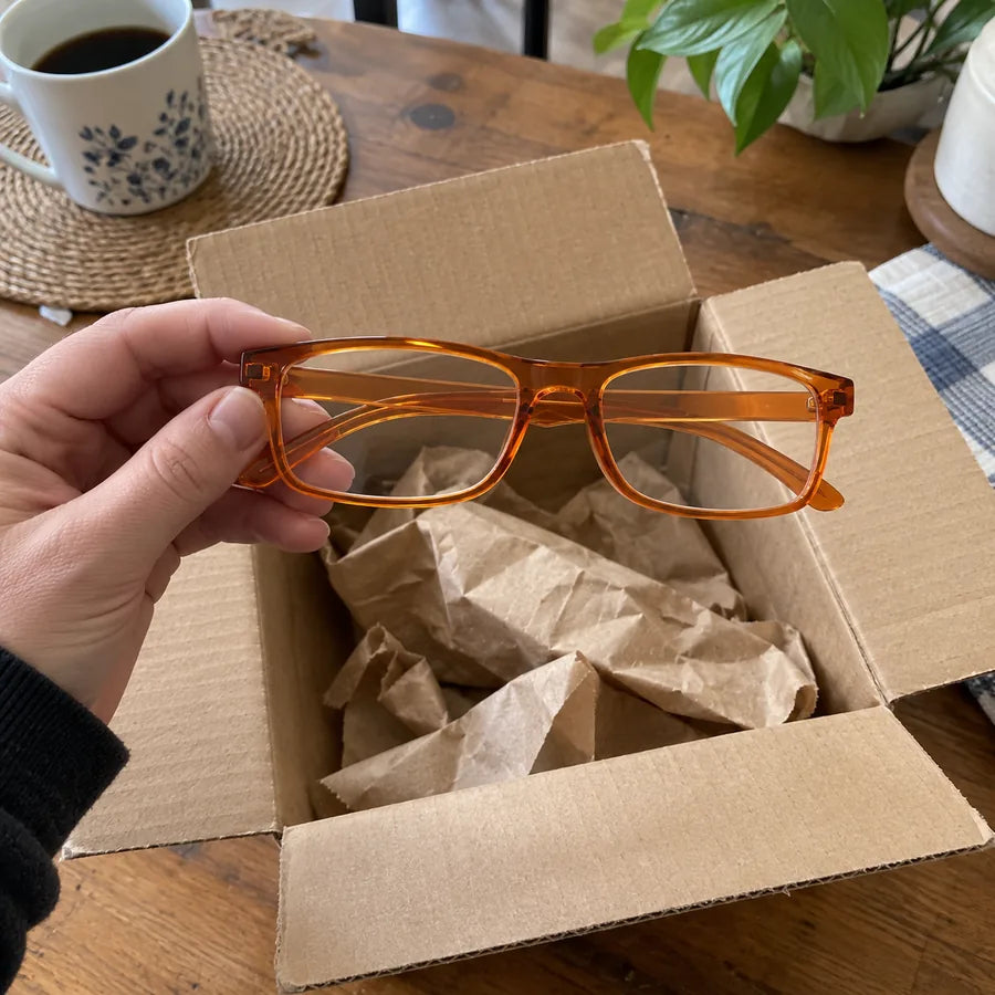 Orange glasses held above an open delivery box